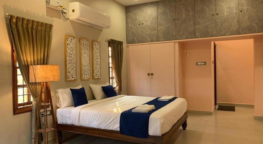 Deluxe Villa sleeping area with wardrobes and a floor lamp