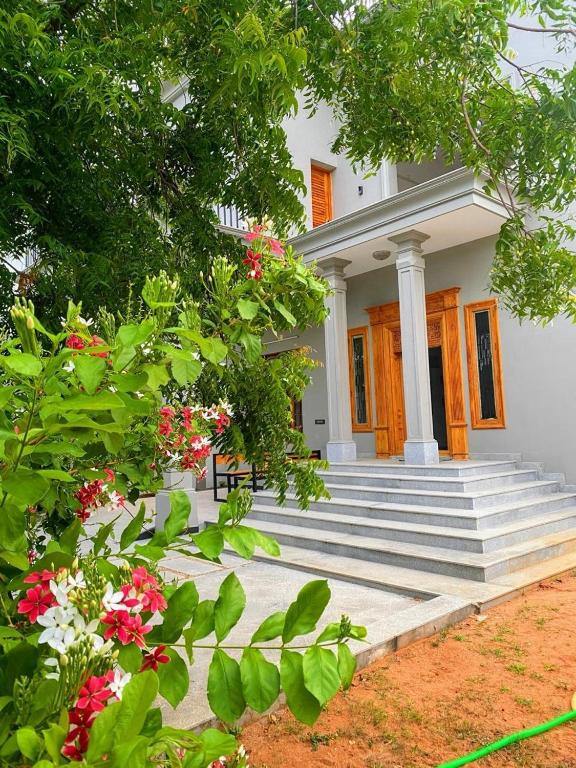 The villa entrance framed by flowering shrubs