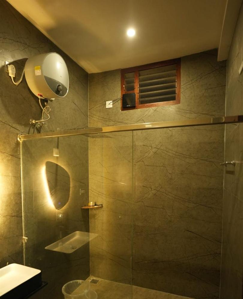 Superior Villa marble bathroom with a walk-in glass shower and lit mirror